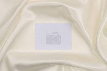 Téléchargez les photos : Cadre en papier toile vide sur fond de tissu de soie beige. Texture abstraite de l'espace de copie. - en image libre de droit