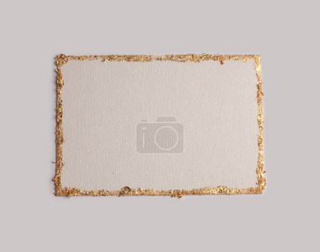 Téléchargez les photos : Carte cadre en toile vide pailletée beige et or sur fond papier gris neutre. Texture abstraite de l'espace de copie. - en image libre de droit