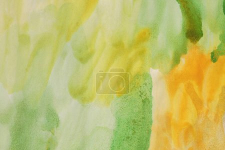 Foto de Tinta acuarela mano dibujado flujo mancha pintura blot sobre papel mojado textura fondo. Verde, Naranja, Color amarillo. - Imagen libre de derechos
