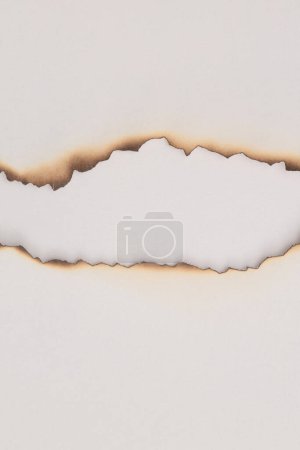 Téléchargez les photos : Vieilles pièces grunge brûlées vides texture carton trou de papier sur fond blanc beige. - en image libre de droit