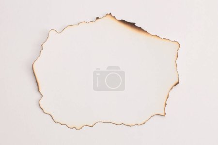 Photo for Empty old torn burned grunge pieces texture cardboard paper frame on beige white background. - Royalty Free Image