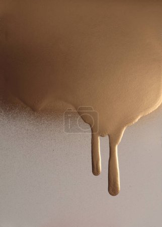 Gold and bronze flow pour spray grain painting texture paper wall background.