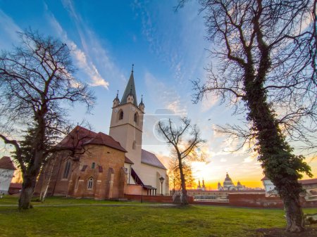 Foto de Targu Mures, ciudad en Transilvania, Rumania, iglesia y fotress al atardecer, cielo dramático - Imagen libre de derechos