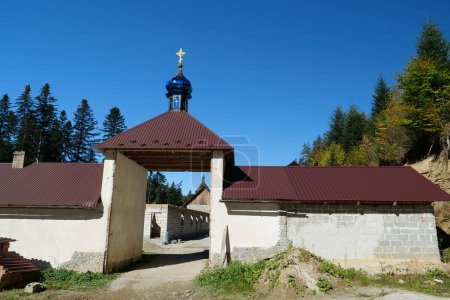 Photo for Manyava Skete of Exaltation of Holy Cross in the forest in Carpathian mountains, Ukraine. Orthodox solitary cell mens monastery, skete. Near skete in wood there is Blessed Stone, object of worship - Royalty Free Image