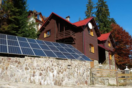 Foto de Self-sufficiency in electricity. Renewable energy. Independent source of green energy. Solar cell panels for country cottage - Imagen libre de derechos