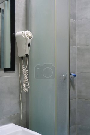 Photo for White hair dryer hanging on the wall in the bathroom - Royalty Free Image
