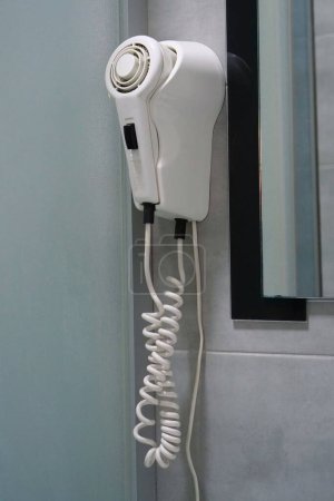 Photo for White hair dryer hanging on the wall in the bathroom - Royalty Free Image