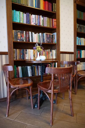 Téléchargez les photos : KOLOMYIE, UKRAINE, 20 AOÛT 2022 : Intérieur du café avec tables, chaises et bibliothèques - en image libre de droit