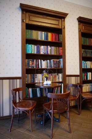 Téléchargez les photos : KOLOMYIE, UKRAINE, 20 AOÛT 2022 : Intérieur du café avec tables, chaises et bibliothèques - en image libre de droit
