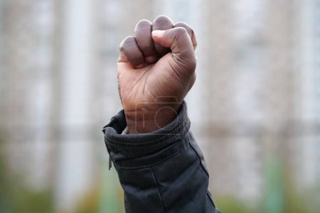 Erhobene schwarze Männerfaust aus Protest. Faust der afrikanisch-amerikanischen, sozialen Gerechtigkeit und friedlicher Protest gegen Rassenungerechtigkeit