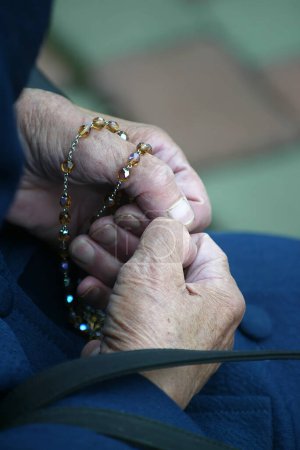 Hände einer Frau, die beim Gebet einen Rosenkranz in der Hand hält, christliche tägliche Andacht eines Verehrers Gottes des Erlösers, Basilika Mariä Himmelfahrt in Marija Bistrica, Kroatien