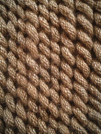 Texture of woven fabric with grainy surface, detailed close-up of rough, tactile material, emphasizing patterns and textures in natural light