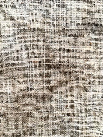 Detailed close-up of rough, tactile woven fabric with grainy surface, showcasing patterns and textures in natural light