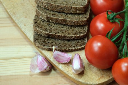Photo for Sliced bread and tomatoes arranged on a cutting board. - Royalty Free Image