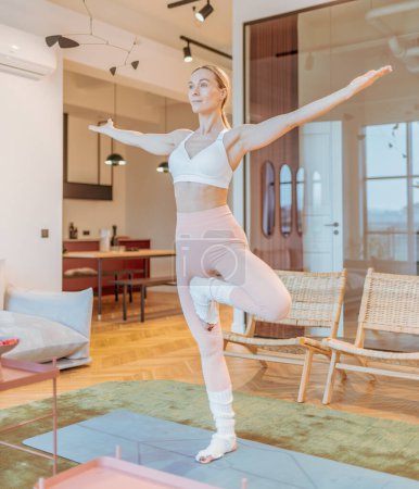 Téléchargez les photos : Femme caucasienne dans l'entraînement de vêtements de sport à la maison, exercice de yoga - en image libre de droit