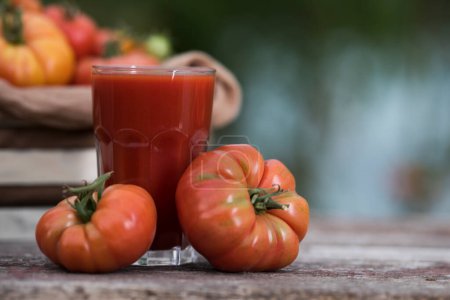 Foto de Jugo de tomate rojo fresco, sobre fondo de madera - Imagen libre de derechos