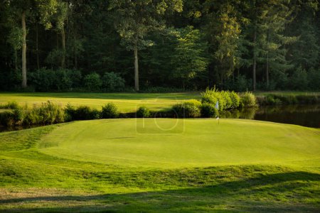 Téléchargez les photos : Terrain de golf vert avec terrain de golf par une journée ensoleillée - en image libre de droit