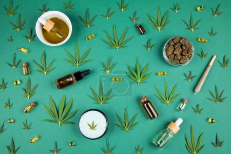Téléchargez les photos : Huile de cannabis et graines de chanvre cbd, feuilles de cannabis, bouteille d'huile et feuilles de marijuana sur papier vert. plan plat, vue sur le dessus - en image libre de droit
