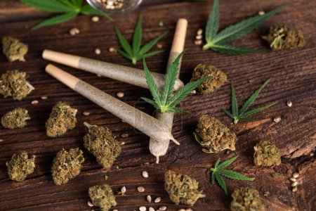 Téléchargez les photos : Bourgeons de marijuana et feuille de marijuana sur table en bois. - en image libre de droit