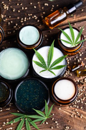 Foto de Semillas de cáñamo y aceite de cannabis en frascos sobre una mesa blanca - Imagen libre de derechos