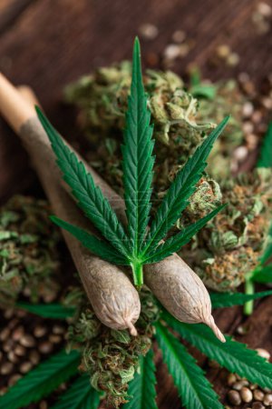 Photo for Marijuana and cannabis leaves on wooden background - Royalty Free Image