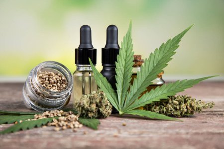 Téléchargez les photos : Huile de cannabis avec graines de chanvre sur fond en bois - en image libre de droit