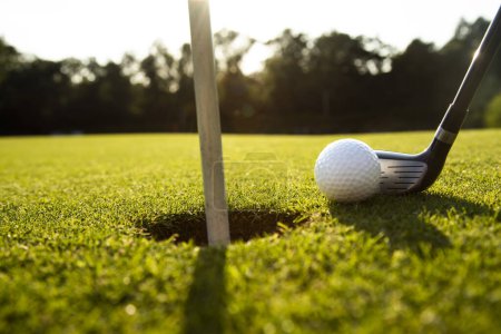 Téléchargez les photos : Équipement de golf dans le club de golf. golf sur le terrain au soleil du soir. - en image libre de droit