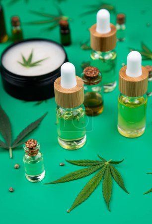 Téléchargez les photos : Hemp oil and cannabis bottles on green background - en image libre de droit