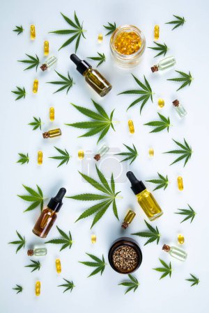 Téléchargez les photos : Bouteilles d'huile de cannabis, graines de chanvre et feuilles fraîches sur fond blanc avec espace de copie - en image libre de droit