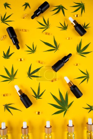 Téléchargez les photos : Bouteilles de marijuana avec de l'huile de cbd et graines de chanvre sur fond jaune. vue du dessus, plan plat - en image libre de droit