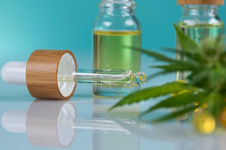 Téléchargez les photos : Cannabis oil in bottle and glass jar on white table - en image libre de droit