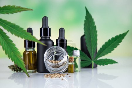Téléchargez les photos : Cbd hemp oil in bottle and marijuana leaves on white background. - en image libre de droit
