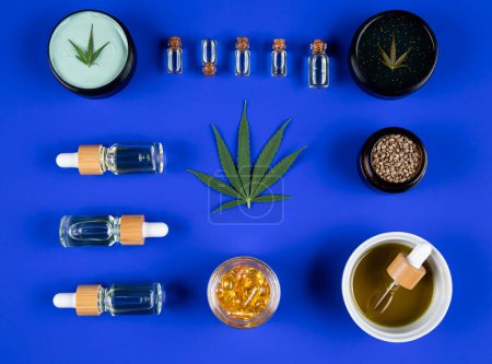 Téléchargez les photos : Ensemble de différentes feuilles de marijuana, bouteilles d'huile, cannabis, huile et chanvre sur fond bleu. - en image libre de droit