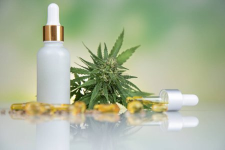 Foto de Aceite de marihuana en botellas con flores de cáñamo cbd sobre un fondo blanco. extracto de cannabis. - Imagen libre de derechos