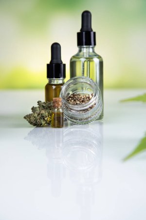 Téléchargez les photos : Huile de cannabis cbd en bouteille de verre avec des feuilles de marijuana et de chanvre, fond blanc - en image libre de droit