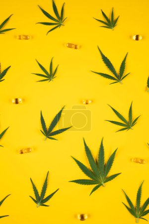 Téléchargez les photos : Feuilles de marijuana sur fond jaune - en image libre de droit
