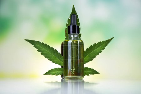 Téléchargez les photos : Bouteille d'huile de chanvre et feuille de cannabis sur fond clair - en image libre de droit