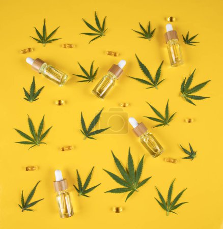 Téléchargez les photos : Composition avec des bouteilles d'huile et de feuilles de marijuana fraîche sur fond de couleur - en image libre de droit