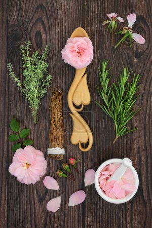 Photo for Ingredients for magic spell love potion natural recipe concoction with rose flowers, rosemary, thyme and ginseng herbs. Nature, wiccan occult composition. On rustic wood. - Royalty Free Image