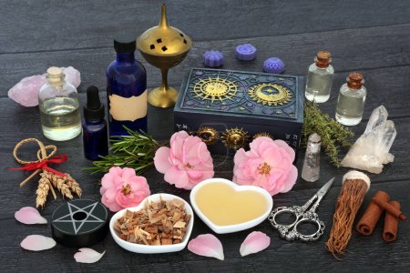 Photo for Pagan love potion aphrodisiac recipe ingredients with herbs, rose flowers, corn dolly, oil, spring water and quartz crystals. Mystical wiccan, shamanic concoction for lovers, fertility and impotence. - Royalty Free Image