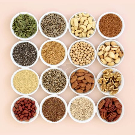 Plant based health food high in lipds. Ingredients contain unsaturated fats for healthy heart and cholesterol levels with nuts, seeds, legumes and grain. On neutral background.