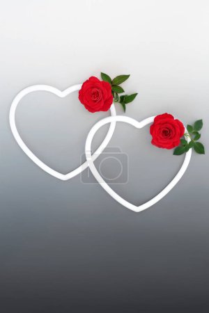 Photo for Valentines Day with two white heart shapes and red rose flowers on gradient grey background. Beautiful love symbol concept for romantic Valentine card. - Royalty Free Image