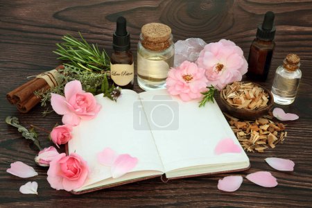 Photo for Aphrodisiac love potion preparation for Valentines Day. Magical spell recipe book or love letter with herbs, rose flowers, oil, spring water and rose quartz crystal. Wiccan occult concoction. - Royalty Free Image