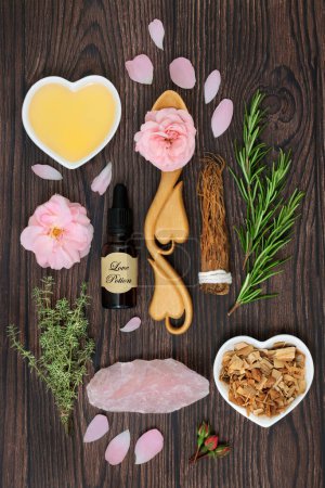 Foto de Love potion and aphrodisiac ingredients for magic spell with herbs, rose flower, honey, concoction in a bottle  and rose quartz crystal. Wiccan occult mystical concept for lovers and Valentines Day. - Imagen libre de derechos