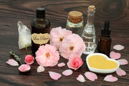 Photo for Valentines day love potion magic spell ingredients with pink rose flowers, honey, quartz crystals, oil, spring water. Wiccan, occult and shamanic mystical concoction for lovers. - Royalty Free Image