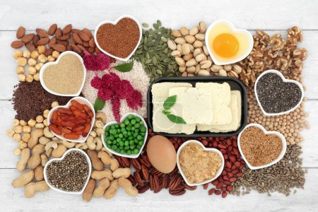 Photo for Vegetarian healthy heart food high in lipids essenital fatty acids containing unsaturated good fats for low cholesterol levels with nuts, seeds, dairy, vitamin e capsules, vegetables and grain. - Royalty Free Image
