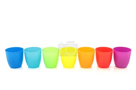 Téléchargez les photos : Tasses à boire arc-en-ciel en ligne sur fond blanc. Composition minimaliste colorée avec thème LGBT trans - en image libre de droit
