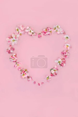 Foto de Corona de flor de manzana en forma de corazón para la primavera. Diseño minimalista abstracto para San Valentín, Pascua, Día de las Madres, cumpleaños para tarjeta, logotipo, etiqueta de regalo o invitación en rosa. - Imagen libre de derechos