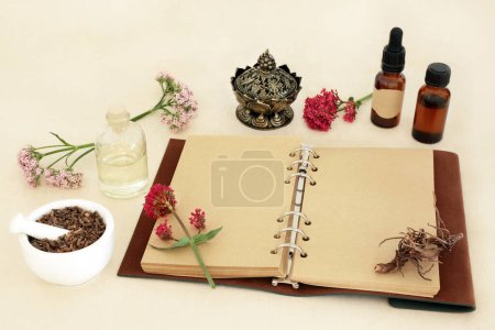 Raíz de valeriana con flores, cuaderno y botellas de aceite esencial. Se utiliza en la medicina herbal para tratar el insomnio, es un sedante y tranquilizante medicamento adaptógeno natural.