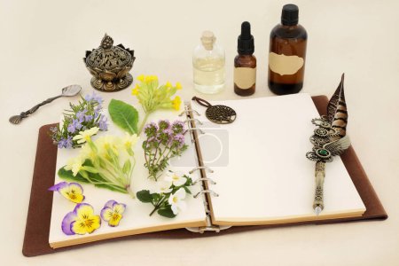 Preparación homeopática de hierbas medicinales con flores de primavera, hierbas y frascos de aceite esencial con cuaderno y pluma de pluma. Concepto floral natural para esencias florales sobre papel de cáñamo.